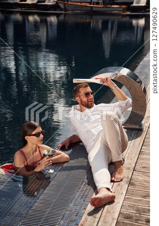 Man with woman is in the pool together Man with woman is in the pool together 127490629