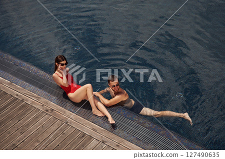 Vacation time, top view. Man with woman is in the pool together Vacation time, top view. Man with woman is in the pool together 127490635