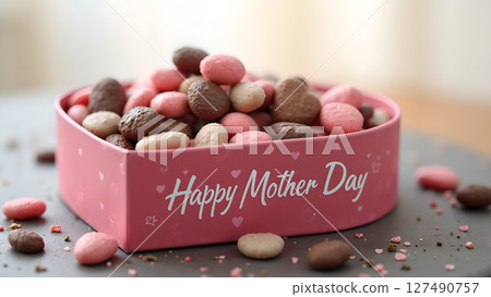 Sweetest Mother's Day: Heart-shaped box overflowing with delicious chocolate candies 127490757