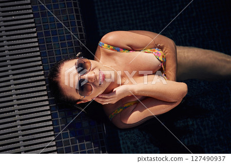 Top view. Beautiful woman that is in swimsuit is in the pool 127490937