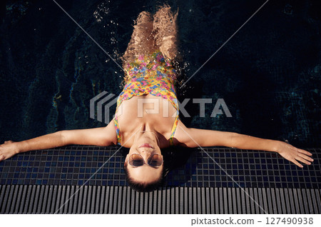 Top view. Beautiful woman that is in swimsuit is in the pool 127490938
