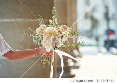 City at background. Close up view of woman that is with flowers in hands 127491249
