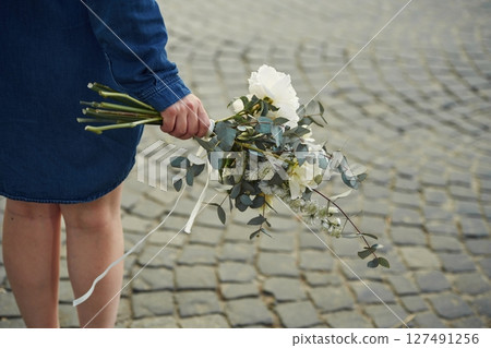 Legs, walking forward. Close up view of woman that is with flowers in hands 127491256