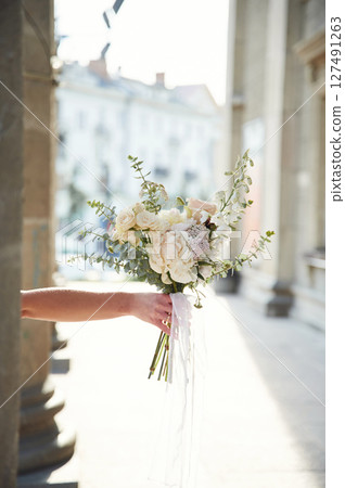 City at background. Close up view of woman that is with flowers in hands City at background. Close up view of woman that is with flowers in hands 127491263