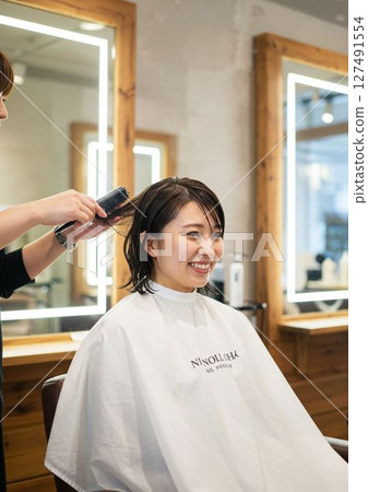 美容院的理髮師和女顧客剪頭髮 美容院的理髮師和女顧客剪頭髮 127491554