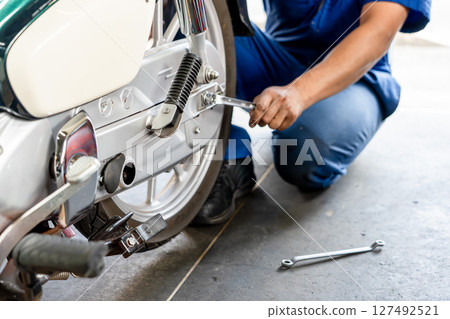 A photo of a mechanic servicing a motorcycle 127492521