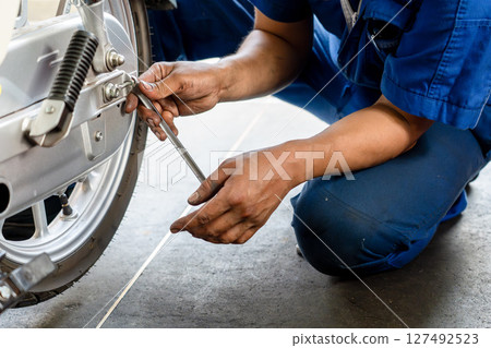 A photo of a mechanic servicing a motorcycle 127492523