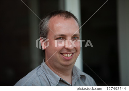 A Smiling Man in Casual Setting Radiating Charm and Authenticity with His Warm Smile 127492544