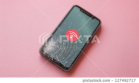 Broken Smartphone Screen Displaying WiFi Signal Icon on Vibrant Background 127492717