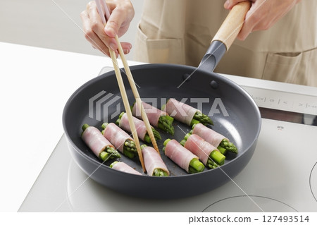 A scene of cooking asparagus bacon in the kitchen 127493514