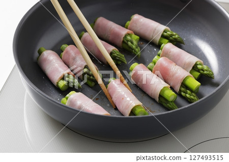 A scene of cooking asparagus bacon in the kitchen A scene of cooking asparagus bacon in the kitchen 127493515