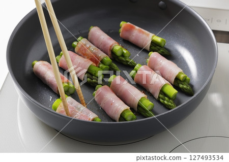 A scene of cooking asparagus bacon in the kitchen A scene of cooking asparagus bacon in the kitchen 127493534