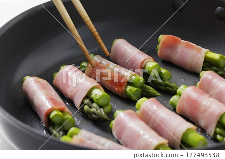 A scene of cooking asparagus bacon in the kitchen A scene of cooking asparagus bacon in the kitchen 127493538