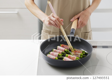 A scene of cooking asparagus bacon in the kitchen A scene of cooking asparagus bacon in the kitchen 127493551