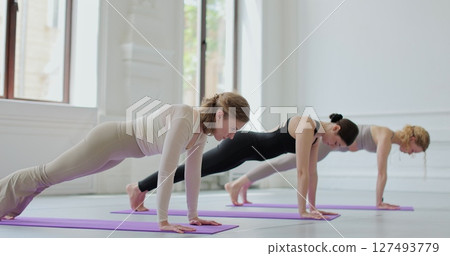 Yoga and women in class stretching in pose for wellness, flexibility and workout. Concept of healthy lifestyles and self development. Yoga and women in class stretching in pose for wellness, flexibility and workout. Concept of healthy lifestyles and self development. 127493779