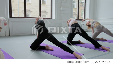 Yoga class of women exercising healthy lifestyle in fitness studio. Lifestyle of sportive yoga with good posture. Healthy lifestyle in fitness studio and gymnastics class. 127493802