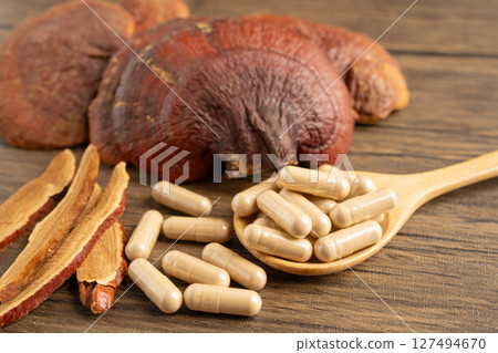 Dried lingzhi mushroom with capsule drug, alternative medicine herbal organic herb. 127494670