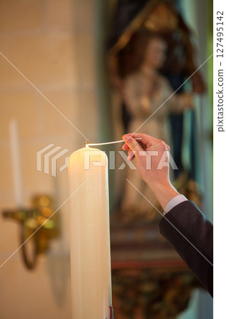 Candle lighting takes place in a serene church setting, creating a beautiful atmosphere Candle lighting takes place in a serene church setting, creating a beautiful atmosphere 127495142