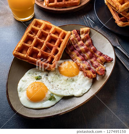 Waffles, fried eggs and crispy bacon breakfast Waffles, fried eggs and crispy bacon breakfast 127495150