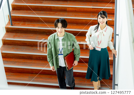 Men and women getting off the stairs 127495777