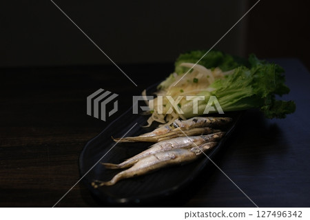 small grilled fish Oven baked fish sardines, with tomatoes, lemon and rosemary. Top view. 127496342