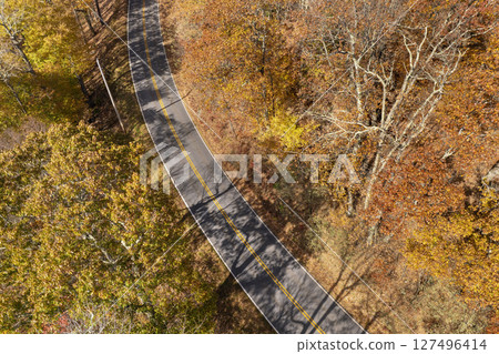Road trip travel in Appalachian mountains. Car driving on parkway through woods nature in fall season. Colorful forest in autumn Tennessee 127496414