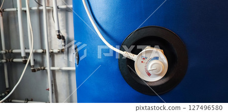 Thermostat control knob on a boiler, gas or hot water boiler. Eco mode concept on a heating system in a kitchen or bathroom. Household appliance concept 127496580