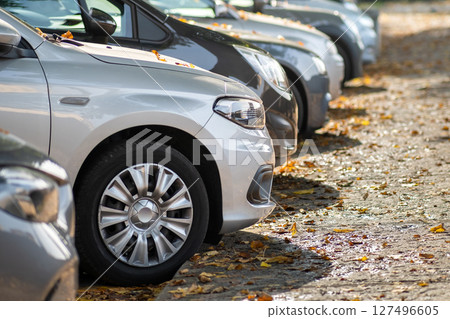 Modern cars parked on city street side in residential discrict. Shiny vehicles parked by the curb. Urban transportation infrastructure concept. 127496605