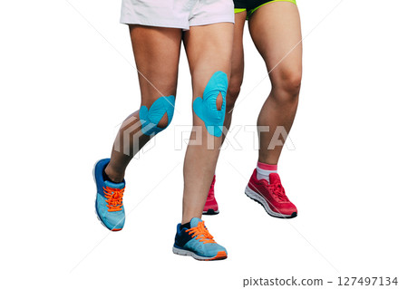 two woman runners running, kinesiology tape on their knees, isolated on white background 127497134