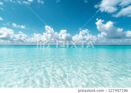 Tranquil turquoise waters reflect fluffy clouds under a bright blue sky at a serene beach during midday 127497196