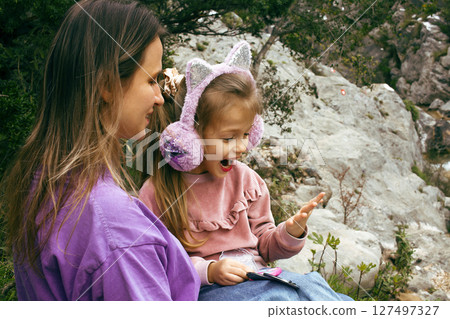 mother with daughter outside doing makeup having fun 127497327