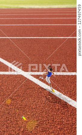 Colorful vertical poster of female sprinter on outdoor track finish line 127497459