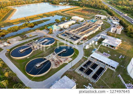 Large-scale industrial water treatment plant purifying and recycling water through filtration and chemical processes to meet health and safety standards 127497645