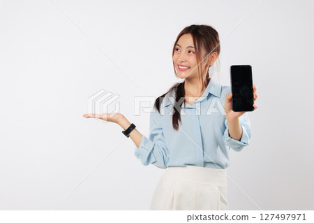 Portrait excited Asian woman hand holds a phone, showing its blank display screen with her palm up side. She is happy to present her new phone. isolated studio white background 127497971