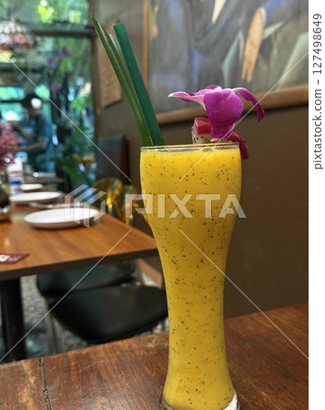 vertical photos Tropical mango smoothie Mango juice in a glass and mango fruit on wooden background. 127498649