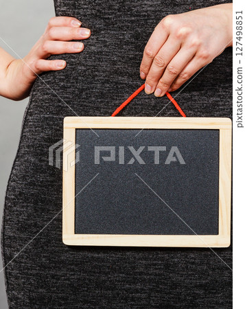 Woman holding blank black board on crotch 127498851
