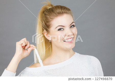 Happy woman holding her bra strap Happy woman holding her bra strap 127498870