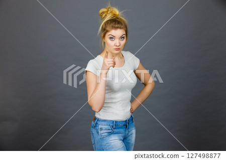 Woman wearing eyeglasses pointing at camera 127498877