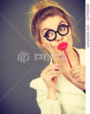 Happy woman holding carnival accessoies on stick 127498888