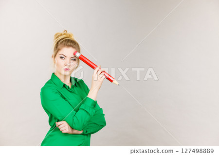 Woman confused thinking, big pencil in hand 127498889