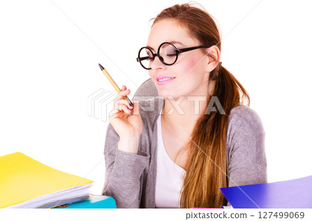 Woman sitting at desk in office and thinking 127499069