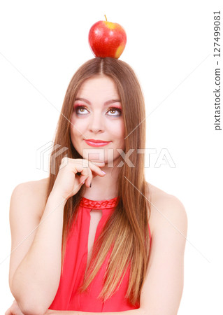 Beautiful woman holds apple fruit on head 127499081