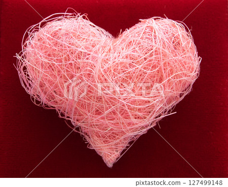Heart shape made of pink material fabric on a red background with copyspace. Concept of Valentine's day and romantic love. Heart shape made of pink material fabric on a red background with copyspace. Concept of Valentine's day and romantic love. 127499148