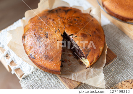 Delicious homemade marbled cake displayed on parchment paper. The swirled chocolate pattern adds a touch of elegance to the dessert, making it perfect for casual gatherings or baking presentations. 127499213