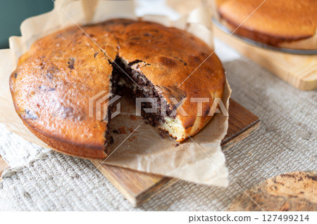 Delicious homemade marbled cake displayed on parchment paper. The swirled chocolate pattern adds a touch of elegance to the dessert, making it perfect for casual gatherings or baking presentations. 127499214