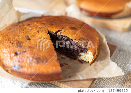 Delicious homemade marbled cake displayed on parchment paper. The swirled chocolate pattern adds a touch of elegance to the dessert, making it perfect for casual gatherings or baking presentations. 127499215