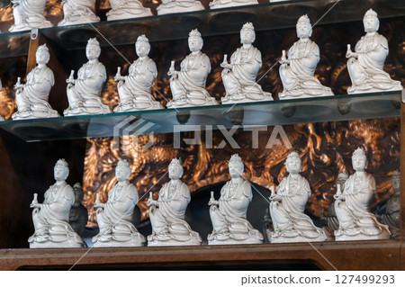 Rows of intricately crafted ceramic figurines, representing spiritual forms Rows of intricately crafted ceramic figurines, representing spiritual forms 127499293