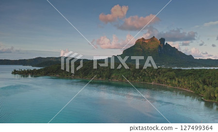 Aerial drone view of mount Otemanu in Bora Bora. French Polynesia. Reflecting in the calm turquoise lagoon at sunset. With lush vegetation in the foreground and a beautiful pink and purple cloudscape Aerial drone view of mount Otemanu in Bora Bora. French Polynesia. Reflecting in the calm turquoise lagoon at sunset. With lush vegetation in the foreground and a beautiful pink and purple cloudscape 127499364