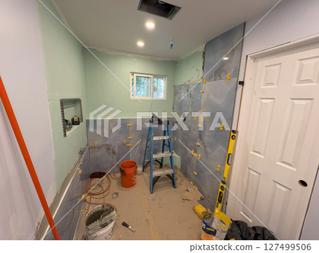 Home Bathroom Renovation Project Showing Tiled Walls and Tools in Progress 127499506