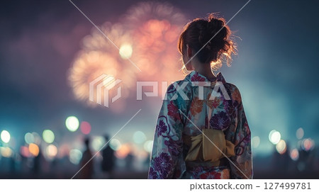 A woman in a yukata looking at fireworks 127499781